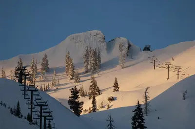 a snow covered mountain with trees and a ski lift at Palisades Tahoe Lodge Rentals Studio Loft #334 in Olympic Valley