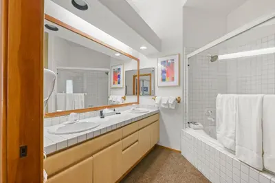 a bathroom with two sinks and a large mirror at Palisades Tahoe Lodge Rentals Two Bedroom #422 in Olympic Valley