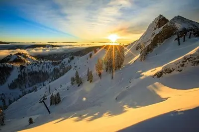a snowy mountain with the sun setting on the horizon at Palisades Tahoe Lodge Rentals Two Bedroom #521 in Olympic Valley