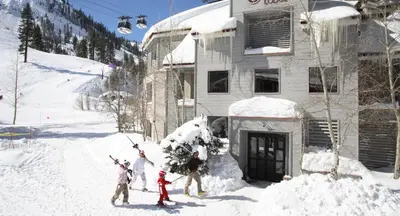 a group of people standing in the snow in front of a building at Palisades Tahoe Lodge Rentals Two Bedroom #521 in Olympic Valley