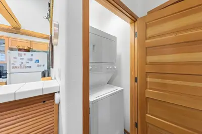 a laundry room with a washer and dryer next to a door at Palisades Tahoe Lodge Rentals Two Bedroom #800 in Olympic Valley