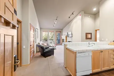a kitchen with a sink and a living room at Palisades Tahoe Lodge Rentals Two Bedroom #809 in Olympic Valley