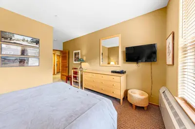 a bedroom with a bed and a flat screen tv at Palisades Tahoe Lodge Rentals Two Bedroom #716 in Olympic Valley