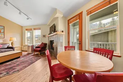 a living room with a table and a fireplace at Palisades Tahoe Lodge Rentals Two Bedroom #813 in Olympic Valley