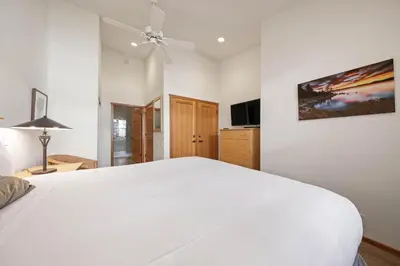 a bedroom with a white bed and a ceiling fan at Two Bedroom #801 in Olympic Valley
