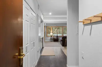 a hallway with a door and a living room at Palisades Tahoe Lodge Rentals Premium Studio #227 in Olympic Valley