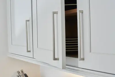 a row of white cabinets with a mirror at Palisades Tahoe Lodge Rentals Premium Studio #105 in Olympic Valley