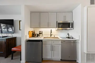 a kitchen with white cabinets and stainless steel appliances at Palisades Tahoe Lodge Rentals Premium Studio #105 in Olympic Valley