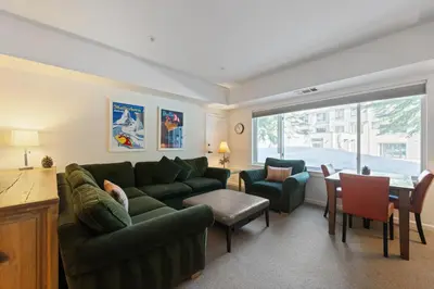 a living room with a green couch and a table at Palisades Tahoe Lodge Rentals Premium Studio #105 in Olympic Valley
