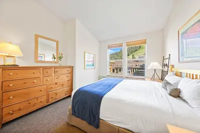 a bedroom with a bed and a dresser and a window at Palisades Tahoe Lodge Rentals Two Bedroom #814 in Olympic Valley