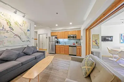 a living room with a couch and a kitchen at Palisades Tahoe Lodge Rentals Premium Studio #149 in Olympic Valley