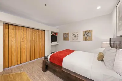 a bedroom with a large bed with a wooden closet at Palisades Tahoe Lodge Rentals Premium Studio #252 in Olympic Valley