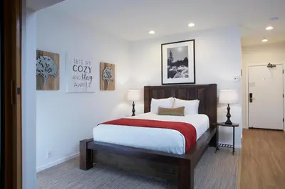 a bedroom with a large bed with a red blanket at Palisades Tahoe Lodge Rentals Premium Studio #252 in Olympic Valley