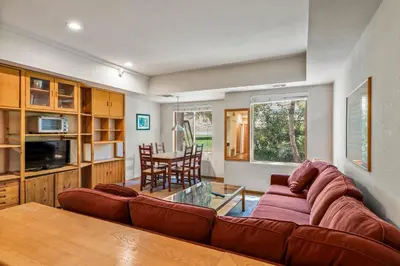 a living room with a couch and a table at Palisades Tahoe Lodge Rentals Studio #104 in Olympic Valley