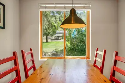 a dining room with a table and a large window at Palisades Tahoe Lodge Rentals Studio #104 in Olympic Valley