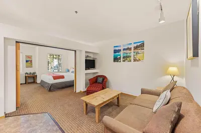 a living room with a couch and a bed at Palisades Tahoe Lodge Rentals Studio #144 in Olympic Valley