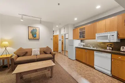 a living room with a couch and a kitchen at Palisades Tahoe Lodge Rentals Studio #144 in Olympic Valley