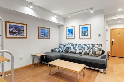 a living room with a couch and a table at Palisades Tahoe Lodge Rentals Studio #109 in Olympic Valley