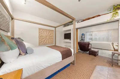 a bedroom with a bed and a desk and a chair at Palisades Tahoe Lodge Rentals Studio #146 in Olympic Valley