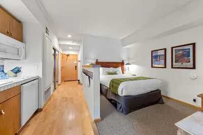 a hotel room with a bed and a kitchen at Palisades Tahoe Lodge Rentals Studio #111 in Olympic Valley