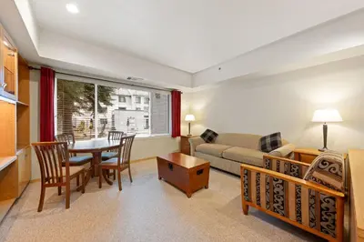 a living room with a table and a couch at Palisades Tahoe Lodge Rentals Studio #113 in Olympic Valley