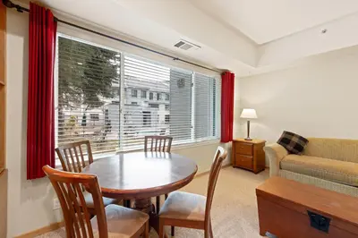 a living room with a table and chairs and a window at Palisades Tahoe Lodge Rentals Studio #113 in Olympic Valley