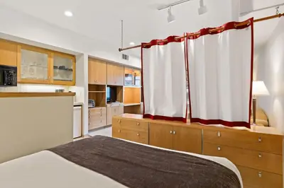 a bedroom with a bed with a red and white curtain at Palisades Tahoe Lodge Rentals Studio #113 in Olympic Valley