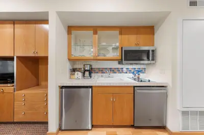 a kitchen with stainless steel appliances and wooden cabinets at Palisades Tahoe Lodge Rentals Studio #118 in Olympic Valley