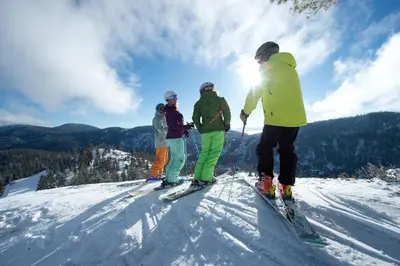 a group of people standing on top of a ski slope at Palisades Tahoe Lodge Rentals Studio #118 in Olympic Valley