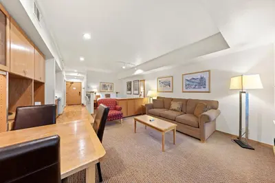 a living room with a couch and a table at Palisades Tahoe Lodge Rentals Studio #118 in Olympic Valley