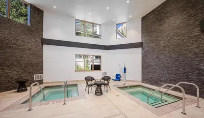 a swimming pool with a table and chairs in a building at Palisades Tahoe Lodge Rentals Studio #147 in Olympic Valley
