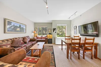 a living room with a couch and a table at Palisades Tahoe Lodge Rentals Studio #151 in Olympic Valley