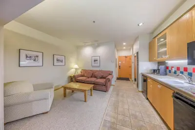a kitchen and living room with a couch and a table at Palisades Tahoe Lodge Rentals Studio #148 in Olympic Valley