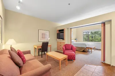 a living room with a couch and a bedroom at Palisades Tahoe Lodge Rentals Studio #155 in Olympic Valley