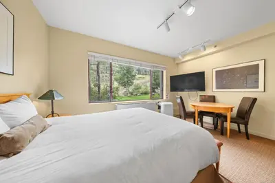 a bedroom with a bed and a desk and a television at Palisades Tahoe Lodge Rentals Studio #155 in Olympic Valley