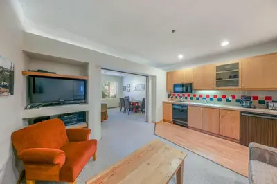 a living room with a kitchen with a table and a couch at Palisades Tahoe Lodge Rentals Studio #158 in Olympic Valley