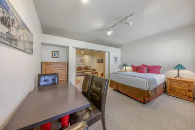 a bedroom with a bed and a table and chairs at Palisades Tahoe Lodge Rentals Studio #158 in Olympic Valley