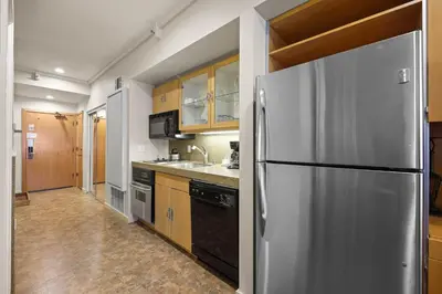 a kitchen with a stainless steel refrigerator and wooden cabinets at Palisades Tahoe Lodge Rentals Studio #217 in Olympic Valley