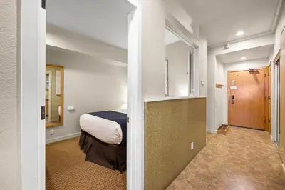 a small room with a bed and a hallway at Palisades Tahoe Lodge Rentals Studio #217 in Olympic Valley