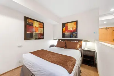 a bedroom with a bed and two pictures on the wall at Palisades Tahoe Lodge Rentals Studio #232 in Olympic Valley