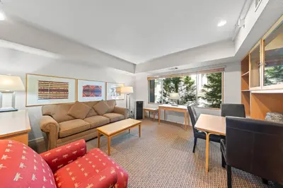 a living room with a couch and a table at Palisades Tahoe Lodge Rentals Studio #215 in Olympic Valley