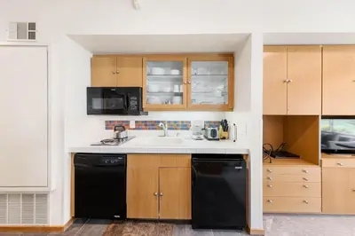 a kitchen with a sink and a black dishwasher at Palisades Tahoe Lodge Rentals Studio #214 in Olympic Valley