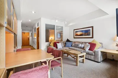 a living room with a couch and a table at Palisades Tahoe Lodge Rentals Studio #223 in Olympic Valley