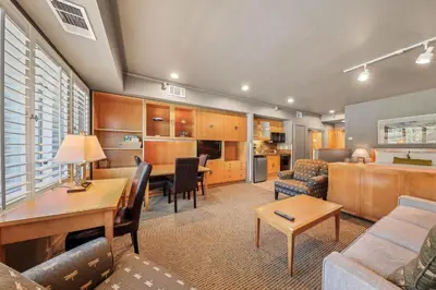 a living room with a couch and a dining room at Palisades Tahoe Lodge Rentals Studio #225 in Olympic Valley
