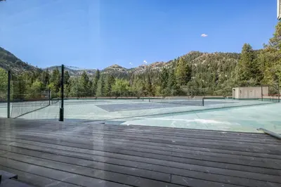 a tennis court with two tennis courtsituresermottermottermott at Palisades Tahoe Lodge Rentals Studio #225 in Olympic Valley