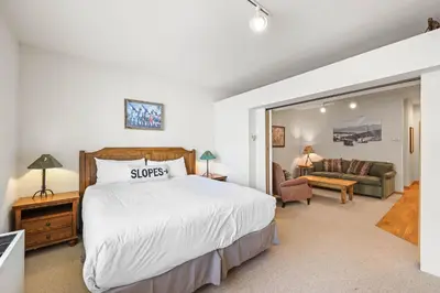 a bedroom with a large bed and a living room at Palisades Tahoe Lodge Rentals Studio #248 in Olympic Valley