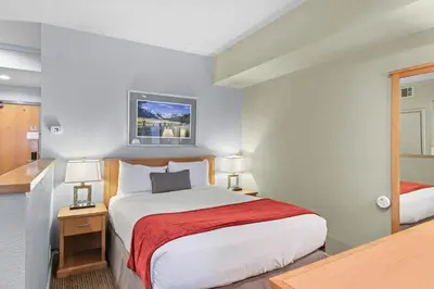 a hotel room with a bed with a red blanket at Palisades Tahoe Lodge Rentals Studio #238 in Olympic Valley