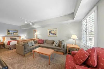 a living room with a couch and a bed at Palisades Tahoe Lodge Rentals Studio #238 in Olympic Valley