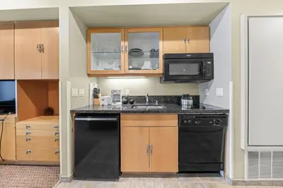 a small kitchen with a sink and a microwave at Palisades Tahoe Lodge Rentals Studio #238 in Olympic Valley