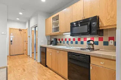 a kitchen with wooden cabinets and a microwave at Palisades Tahoe Lodge Rentals Studio #247 in Olympic Valley
